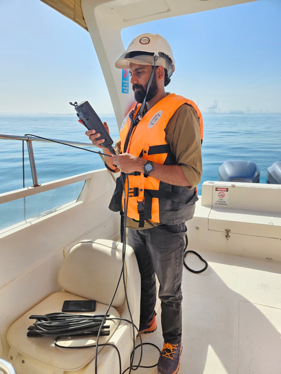 GCEEC environmental engineer conducting marine water quality monitoring from a survey boat in UAE waters